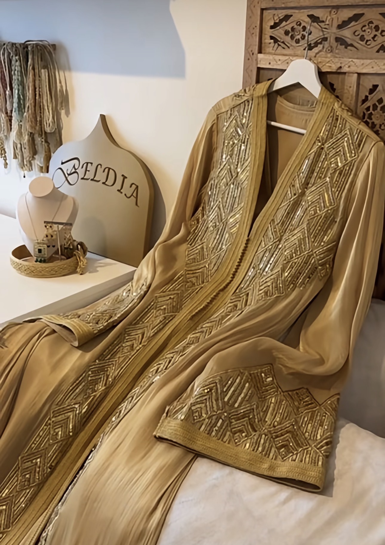 Gouden caftan met paillettenwerk op een hanger in de Beldia-showroom